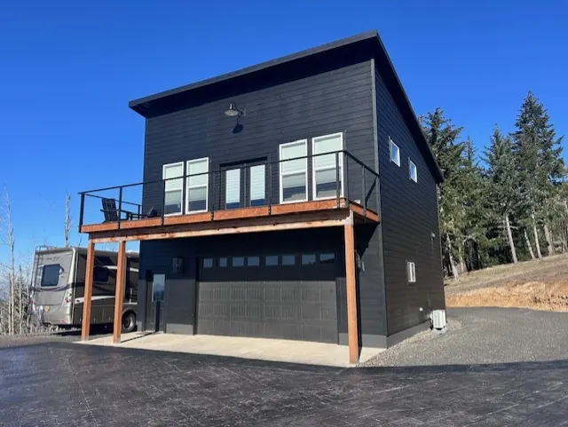 Modern two-story building with a shed roof, charcoal siding and a cedar-trimmed balcony