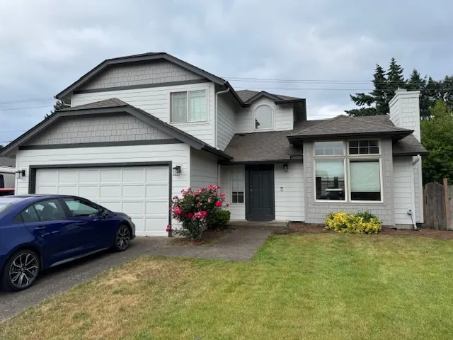 Two-story home with light gray lap and shingle siding and dark trim