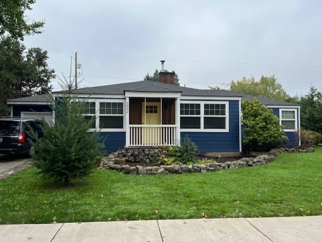 Navy single-story home with a yellow front door