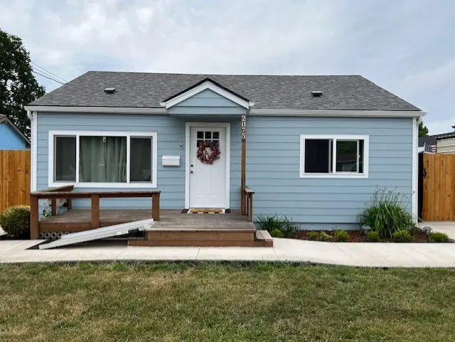 Light blue single-story home with white trim and a wooden deck