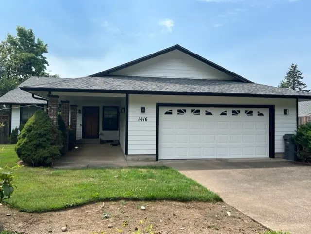 White single-story home with black trim and a two-car garage