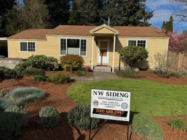 Yellow single-story home with new siding and landscaped beds
