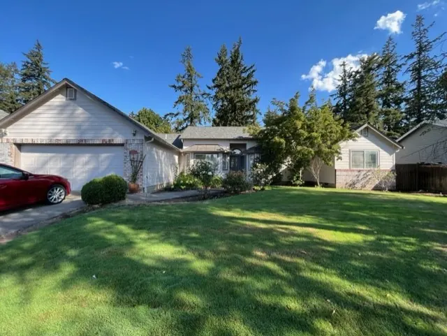 Single-story home with cream siding and a large lawn
